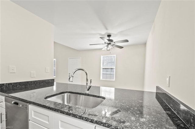 kitchen featuring sink, ceiling fan, dishwasher, dark stone countertops, and white cabinets