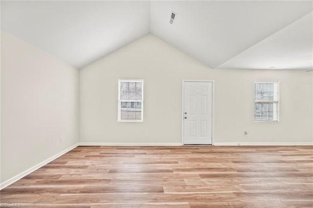 empty room featuring light hardwood / wood-style flooring and vaulted ceiling