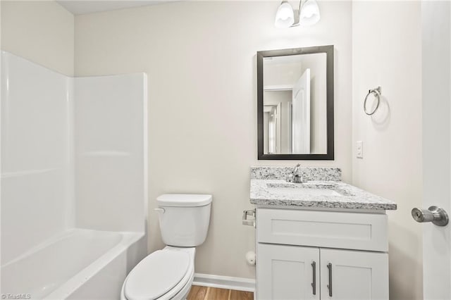 full bathroom featuring hardwood / wood-style flooring, shower / washtub combination, vanity, and toilet