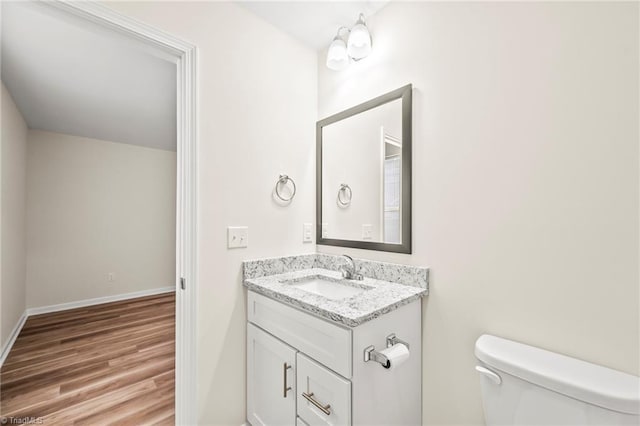 bathroom featuring toilet, vanity, and wood-type flooring