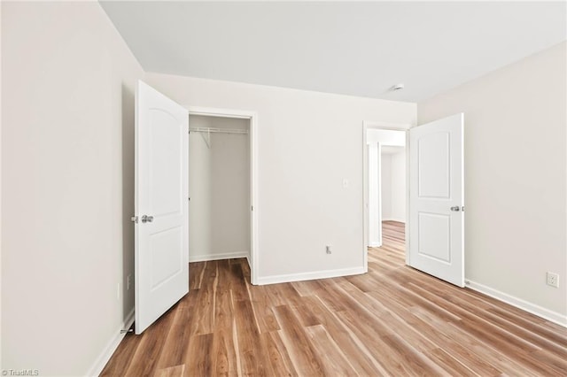 unfurnished bedroom featuring hardwood / wood-style floors and a closet