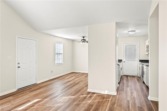 interior space with ceiling fan, vaulted ceiling, and wood-type flooring