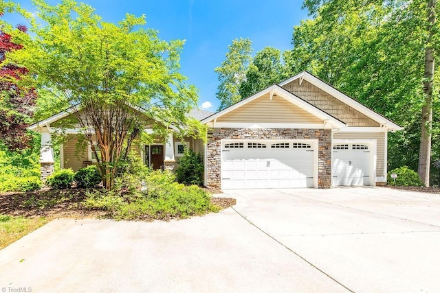 view of front of house with concrete driveway, stone siding, and a garage