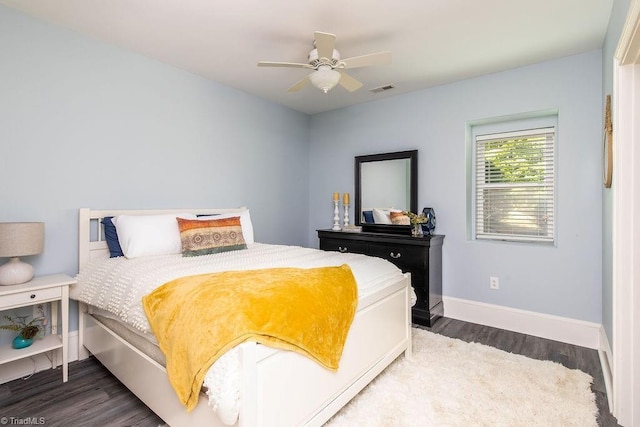 bedroom with visible vents, a ceiling fan, baseboards, and wood finished floors