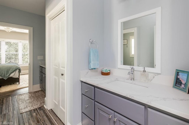 bathroom featuring vanity, baseboards, ensuite bath, and wood finished floors