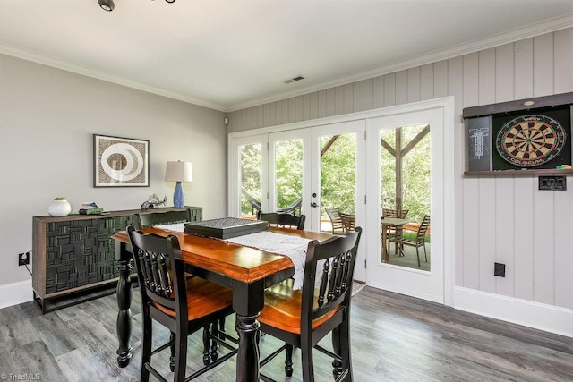 dining space featuring crown molding, visible vents, wood finished floors, baseboards, and french doors