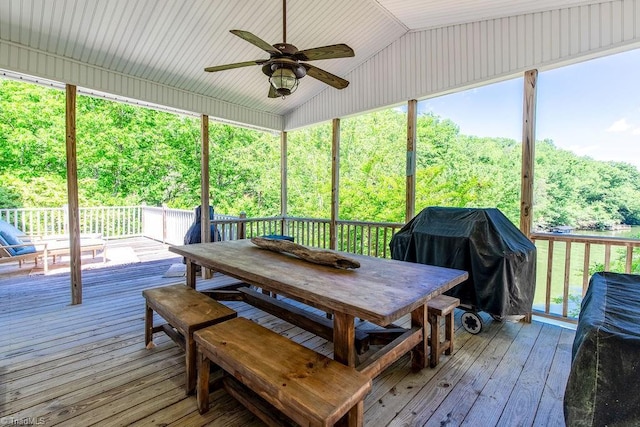 wooden terrace with area for grilling, a ceiling fan, and outdoor dining space