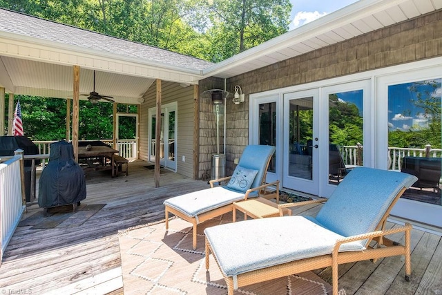 wooden deck featuring outdoor dining area, a ceiling fan, and french doors