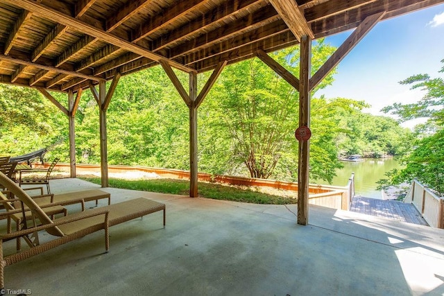 view of patio with a water view and a boat dock