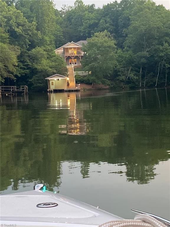dock area with a view of trees and a water view