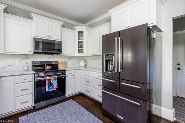 kitchen with light stone countertops, glass insert cabinets, white cabinets, dark wood finished floors, and appliances with stainless steel finishes