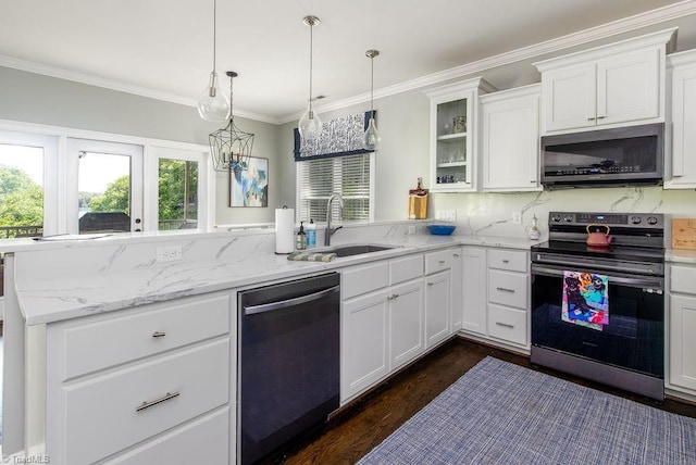 kitchen featuring appliances with stainless steel finishes, a sink, a peninsula, white cabinetry, and ornamental molding