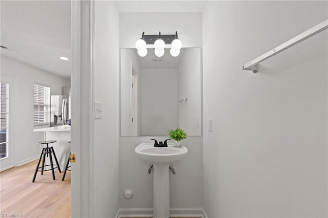 bathroom featuring visible vents, baseboards, and wood finished floors