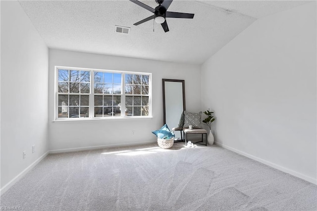 unfurnished room with a textured ceiling, carpet floors, visible vents, and baseboards