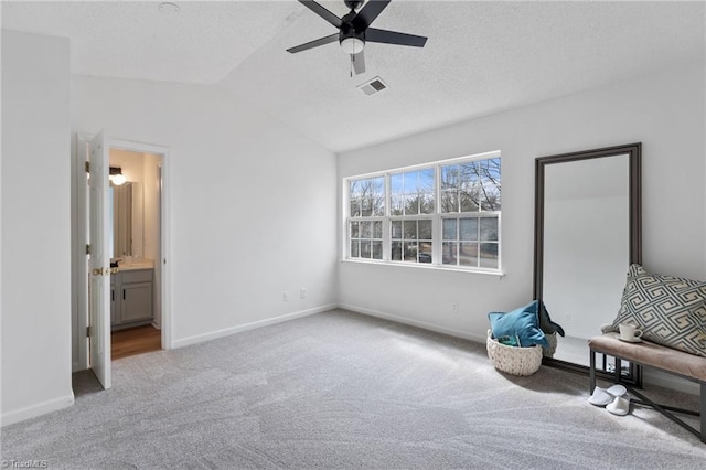 unfurnished bedroom featuring vaulted ceiling, carpet floors, a textured ceiling, and baseboards