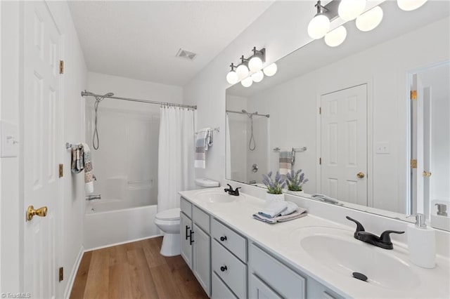 full bath featuring visible vents, a sink, toilet, and wood finished floors