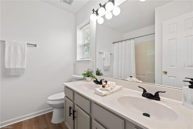 bathroom with a shower with curtain, visible vents, a sink, and toilet