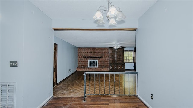 living room with ceiling fan with notable chandelier, dark hardwood / wood-style flooring, and a fireplace