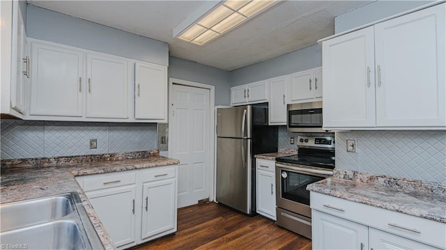 kitchen with white cabinets, stainless steel appliances, and backsplash