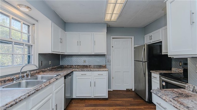 kitchen featuring decorative backsplash, sink, white cabinets, and appliances with stainless steel finishes