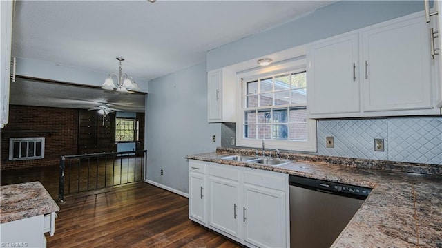 kitchen with a fireplace, white cabinetry, hanging light fixtures, stainless steel dishwasher, and sink