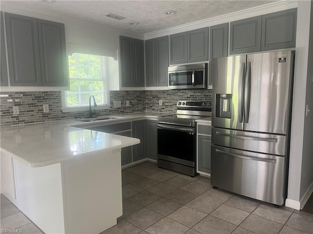 258 S Boyles St, Pilot Mountain, NC 27041 - kitchen featuring stainless steel appliances, a sink, a peninsula, a textured ceiling, and backsplash