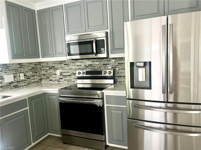 258 S Boyles St, Pilot Mountain, NC 27041 - kitchen with appliances with stainless steel finishes, light countertops, tasteful backsplash, tile patterned floors, and gray cabinetry