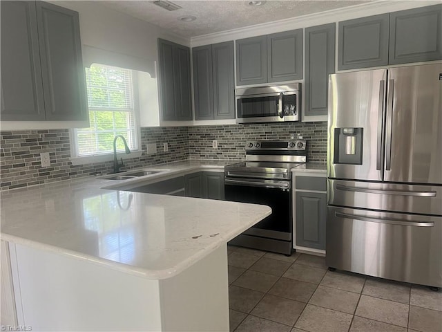 258 S Boyles St, Pilot Mountain, NC 27041 - kitchen with appliances with stainless steel finishes, a sink, a peninsula, light tile patterned floors, and tasteful backsplash