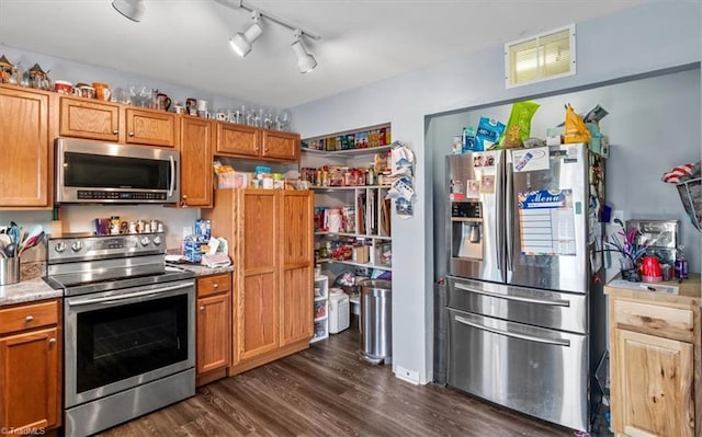 kitchen featuring dark hardwood / wood-style flooring, stainless steel appliances, and track lighting