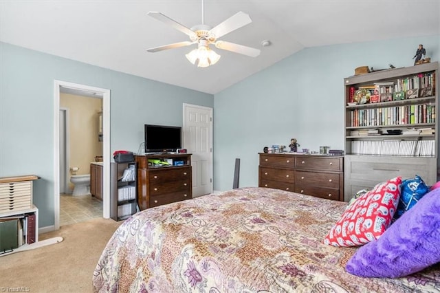 bedroom with light carpet, ensuite bath, vaulted ceiling, and ceiling fan