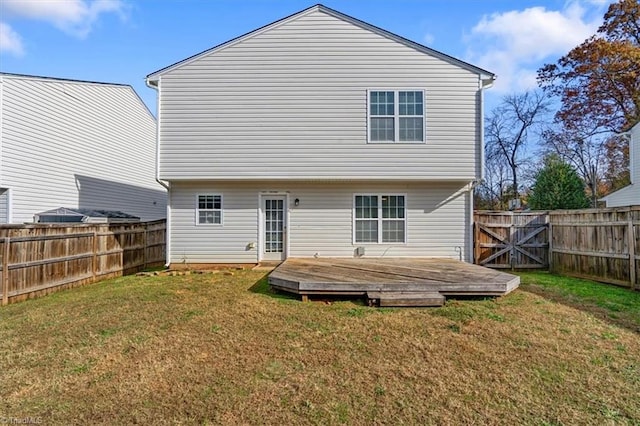 back of house featuring a lawn and a deck