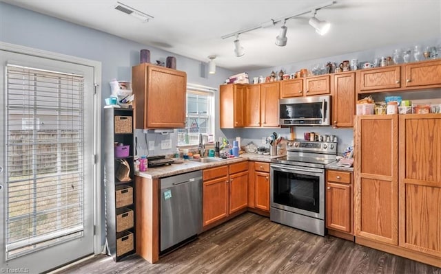 kitchen featuring dark hardwood / wood-style flooring, stainless steel appliances, rail lighting, and sink