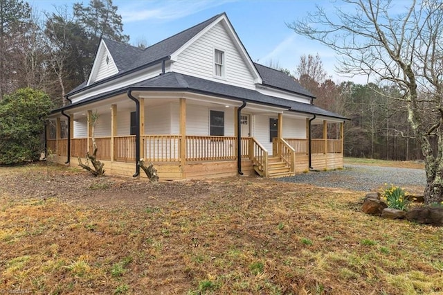 farmhouse inspired home with gravel driveway, covered porch, and a shingled roof