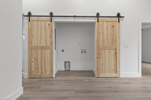 laundry room with wood finished floors, hookup for an electric dryer, laundry area, washer hookup, and a barn door