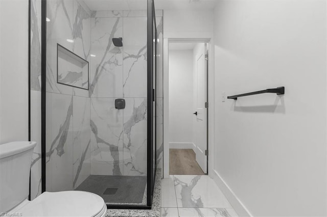 full bathroom with a marble finish shower, marble finish floor, toilet, and baseboards