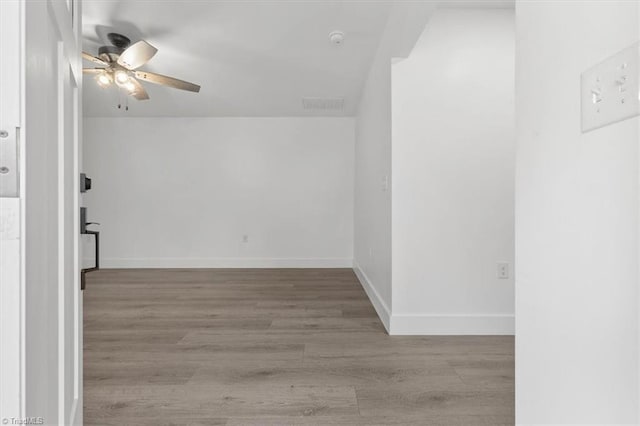 unfurnished room featuring visible vents, baseboards, ceiling fan, and wood finished floors