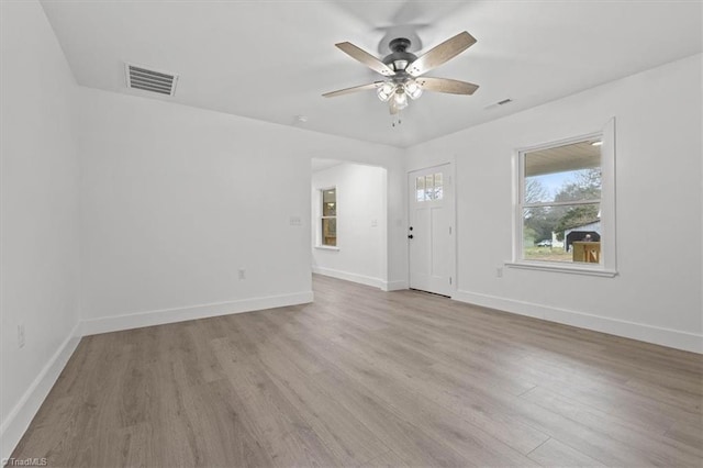 interior space featuring a ceiling fan, wood finished floors, visible vents, and baseboards