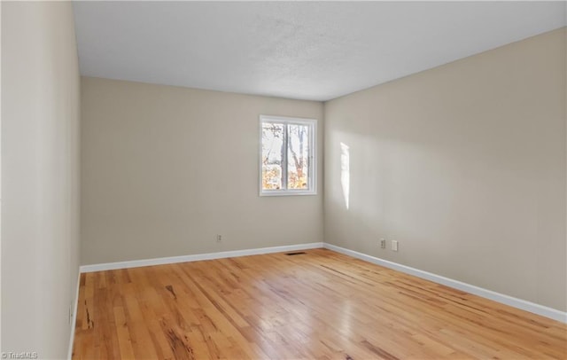 spare room with light hardwood / wood-style flooring