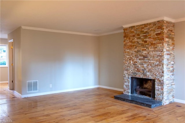 unfurnished living room with a stone fireplace, crown molding, and hardwood / wood-style floors