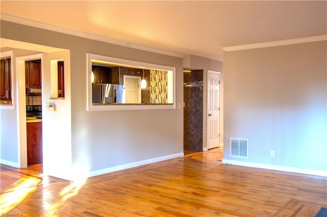 spare room with ornamental molding and wood-type flooring