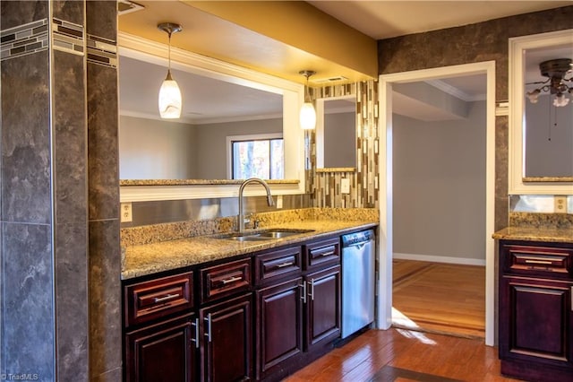 kitchen with dark hardwood / wood-style floors, stainless steel dishwasher, hanging light fixtures, sink, and ornamental molding