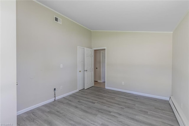 spare room with lofted ceiling, light hardwood / wood-style flooring, baseboard heating, and crown molding