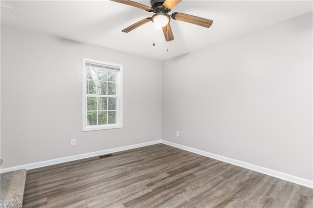 empty room with ceiling fan and dark hardwood / wood-style flooring