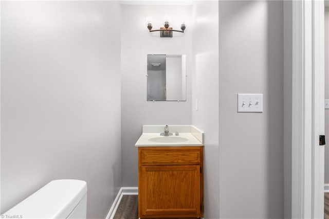 bathroom with hardwood / wood-style floors, vanity, and toilet