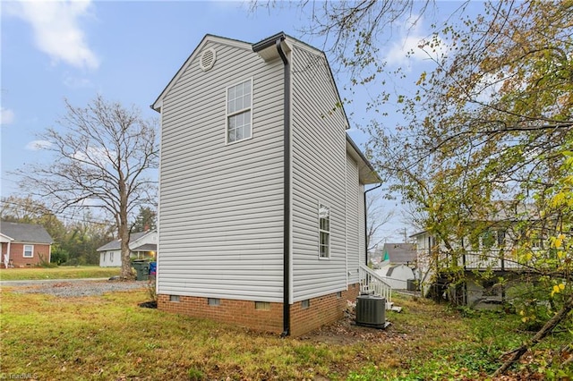 view of side of property with a lawn and central AC unit