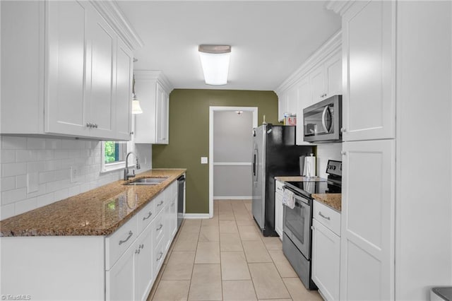 2703 W Cornwallis Dr, Greensboro, NC 27408 - kitchen with a sink, white cabinetry, decorative backsplash, and appliances with stainless steel finishes