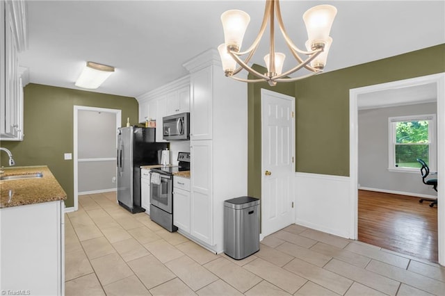 2703 W Cornwallis Dr, Greensboro, NC 27408 - kitchen featuring white cabinets, stone countertops, stainless steel appliances, and a sink