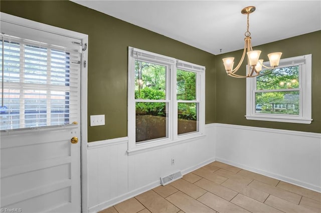 2703 W Cornwallis Dr, Greensboro, NC 27408 - unfurnished dining area with light tile patterned flooring, a chandelier, visible vents, and wainscoting