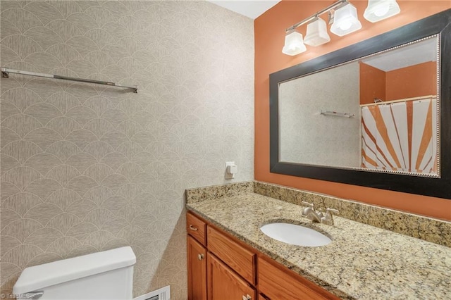 2703 W Cornwallis Dr, Greensboro, NC 27408 - bathroom with curtained shower, vanity, toilet, and wallpapered walls