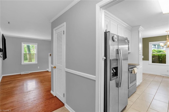 2703 W Cornwallis Dr, Greensboro, NC 27408 - kitchen featuring stainless steel appliances, white cabinets, visible vents, and plenty of natural light